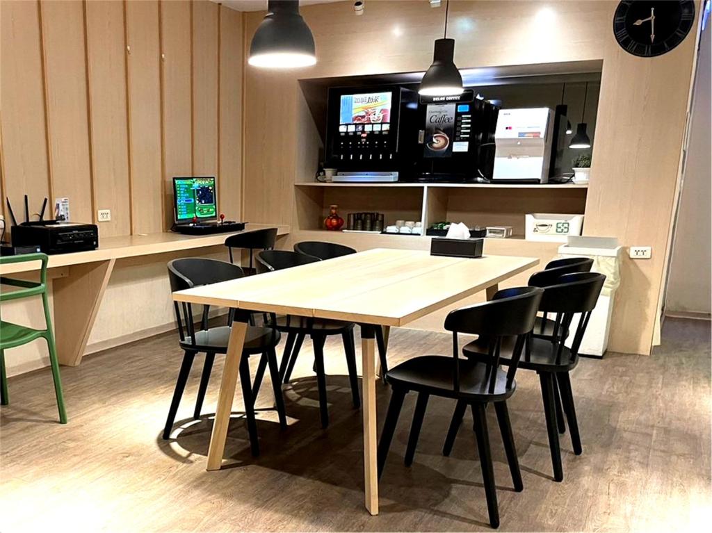 a table and chairs in a room with a kitchen at Yomi Hotel - ShuangLian MRT in Taipei