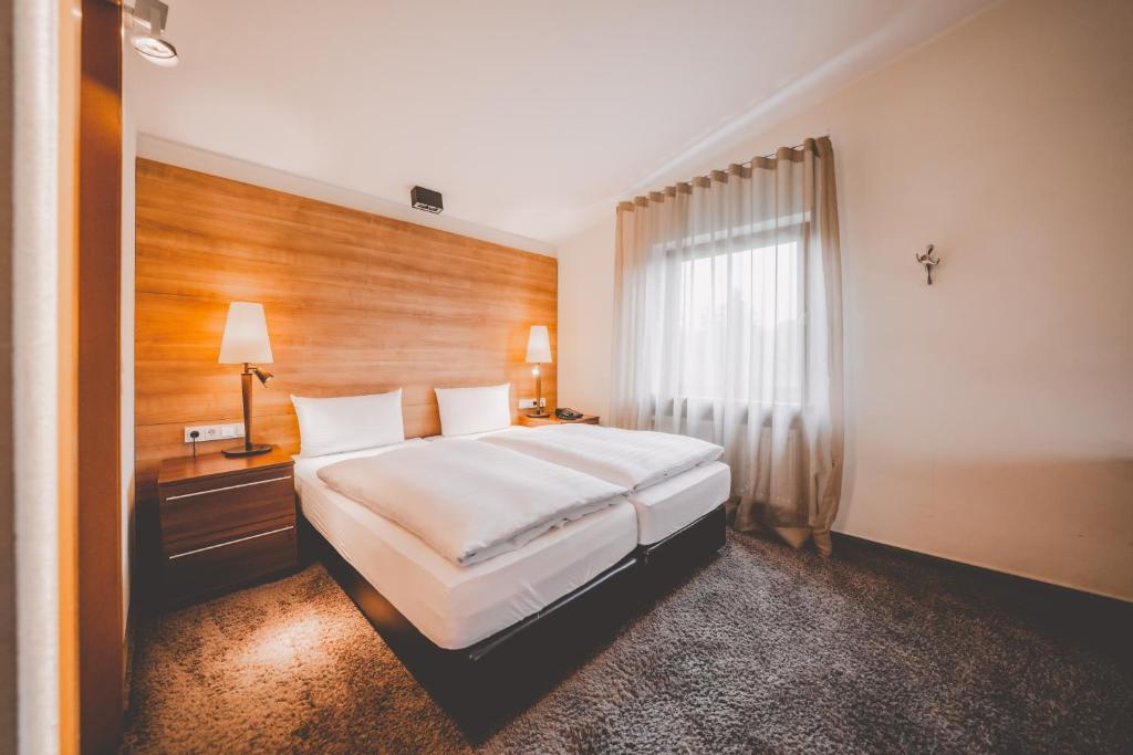 a hotel room with a bed and a window at Das Marienhöh in Langweiler