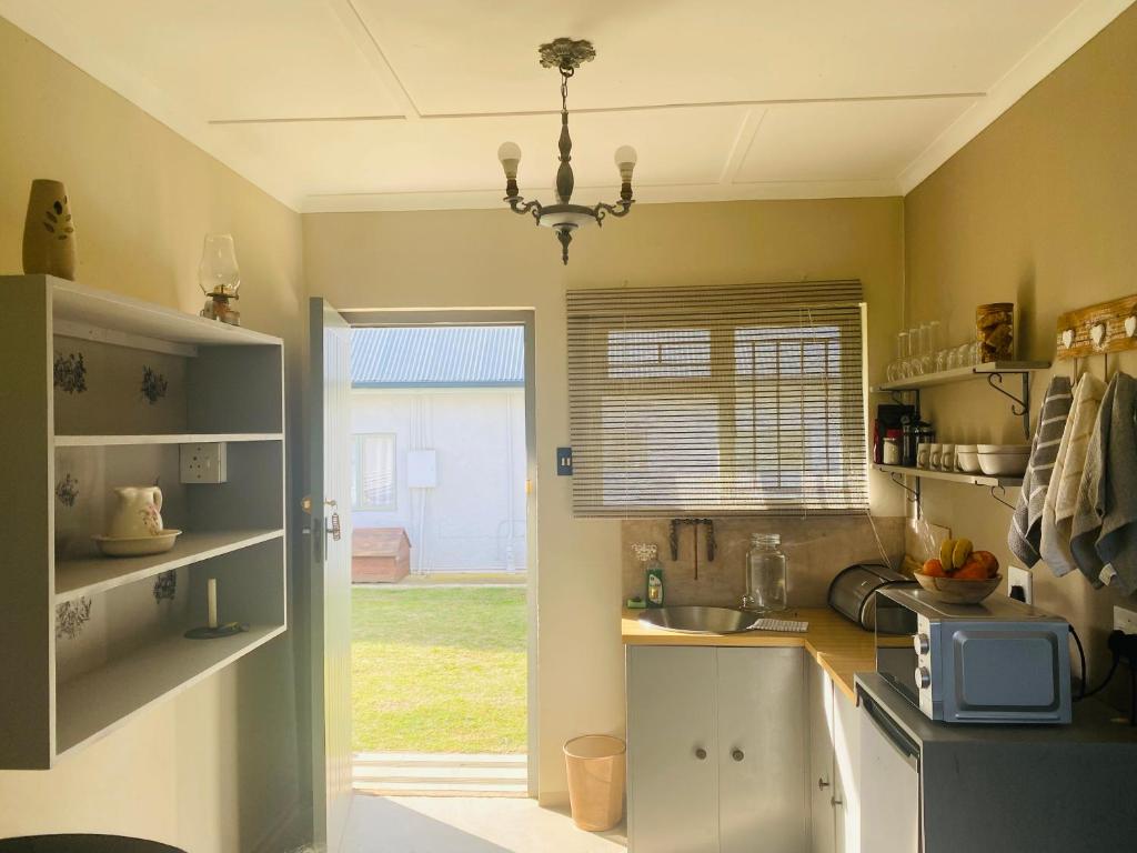 a kitchen with a sink and a counter with a window at Doornboom Farm Self Service in Heidelberg