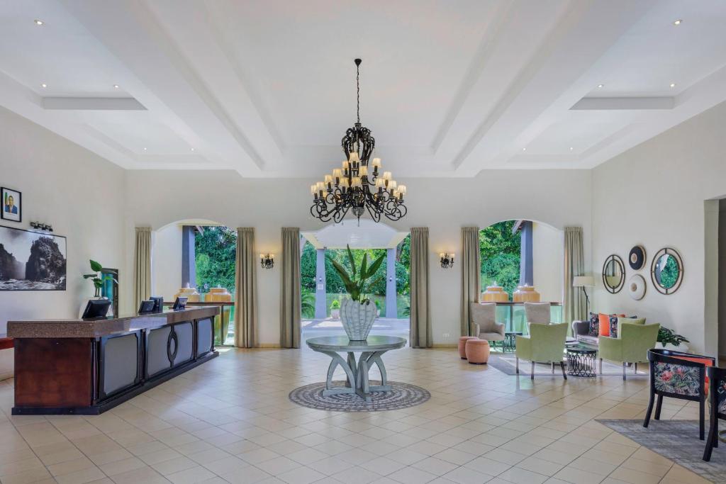 uma grande sala de estar com um lustre e uma mesa em Protea Hotel by Marriott Livingstone em Livingstone