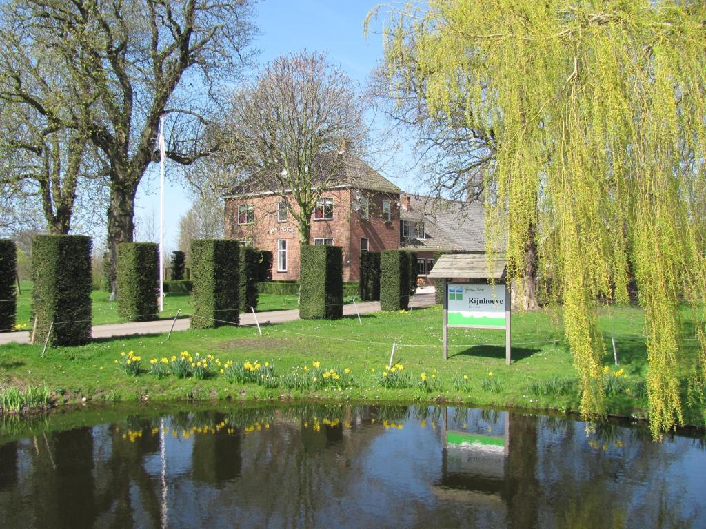 une maison avec un étang en face d'un bâtiment dans l'établissement Appartementen Rijnhoeve, à Koudekerk aan den Rijn