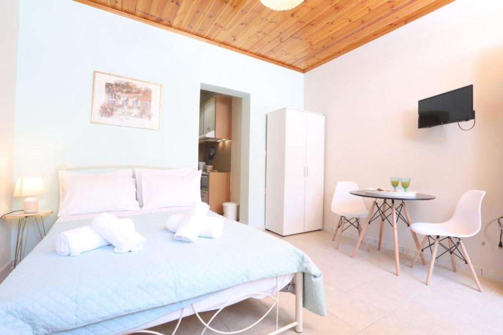 sypialnia z łóżkiem, stołem i krzesłami w obiekcie Andromache's w mieście Gastouri