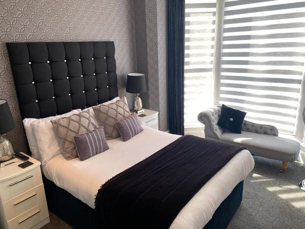 a bedroom with a large bed and a chair at Aaron in Southport