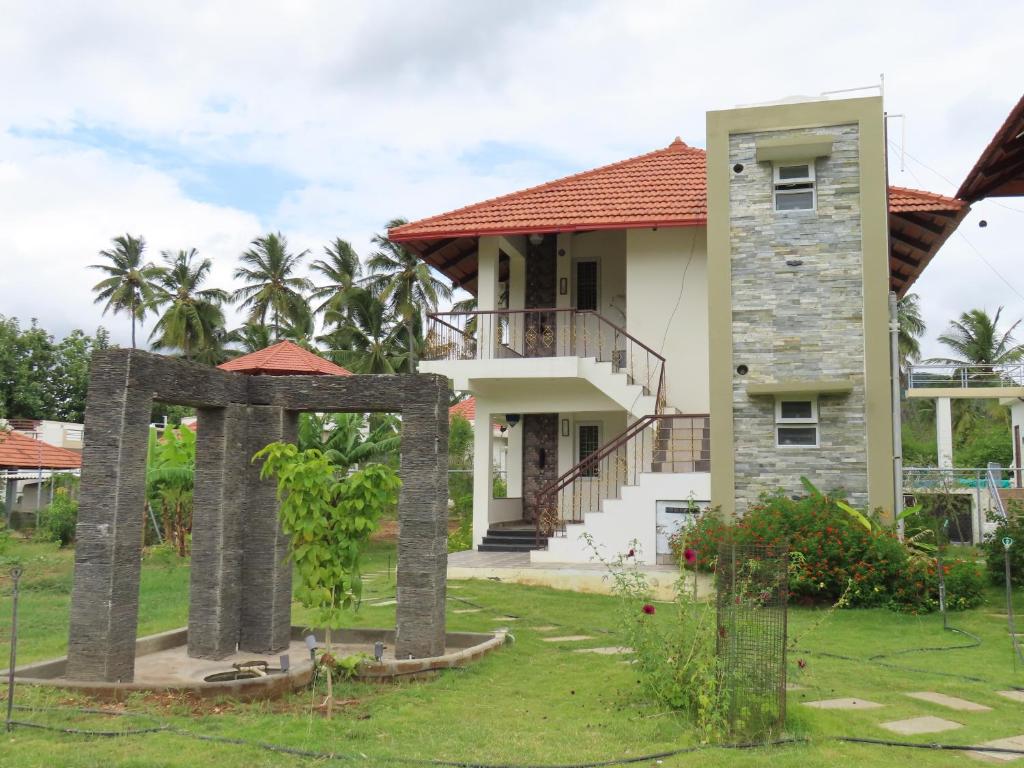 a house with a stone arch in front of it at Misty Hills Retreat in Coimbatore
