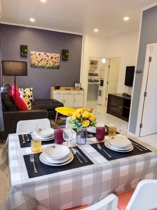 a living room with a table with plates and flowers at Karon Holiday Home by Bcare in Karon Beach