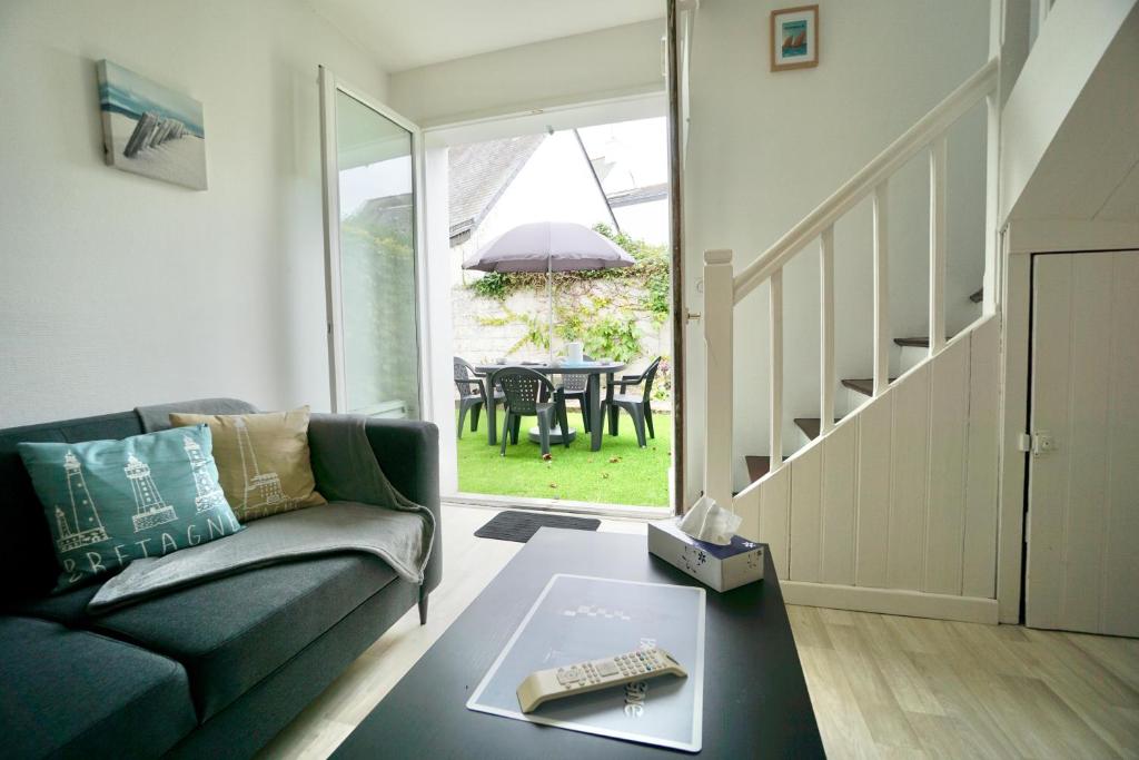 a living room with a couch and a table at Cabine de plage n°1 *50m de la mer* in Ploemeur