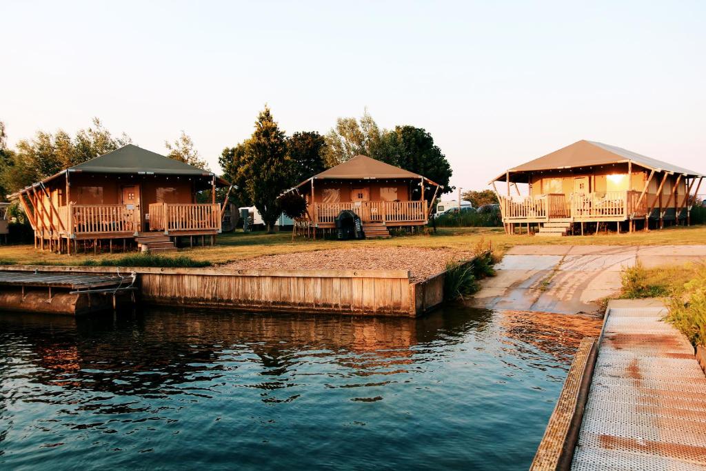 a couple of cottages next to a body of water at Luxury Lake Lodge in Alphen