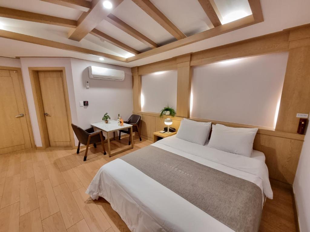 a bedroom with a large bed and a table at LEX Tourist Hotel in Seoul