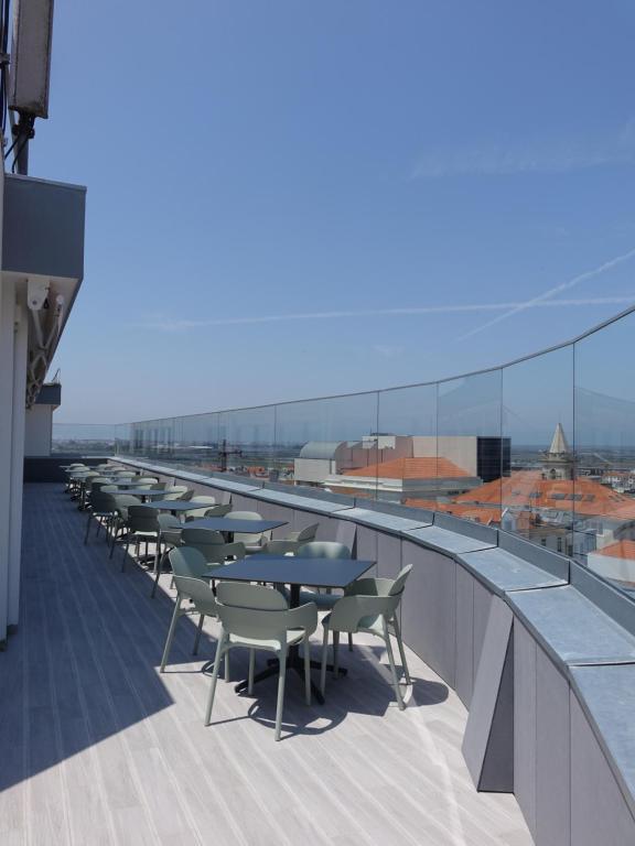 une rangée de tables et de chaises sur un toit dans l'établissement Hotel Imperial, à Aveiro