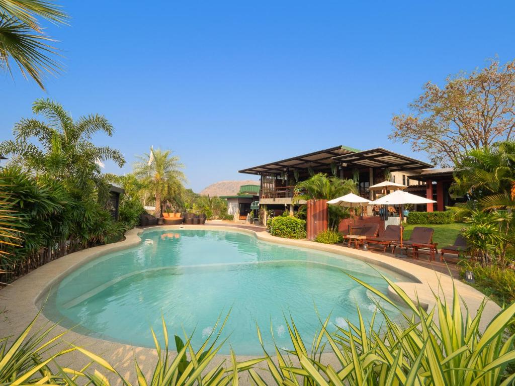 a large swimming pool in front of a house at Best Way Resort in Pak Chong