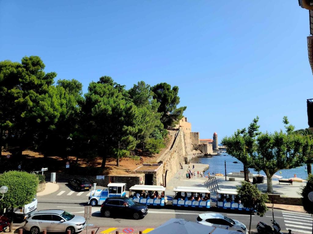 a group of cars parked in a parking lot next to the water at Charmante maison de village Collioure in Collioure