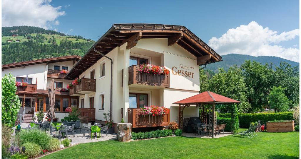 un edificio con un patio con sillas y mesas en Hotel Gesser, en Sillian