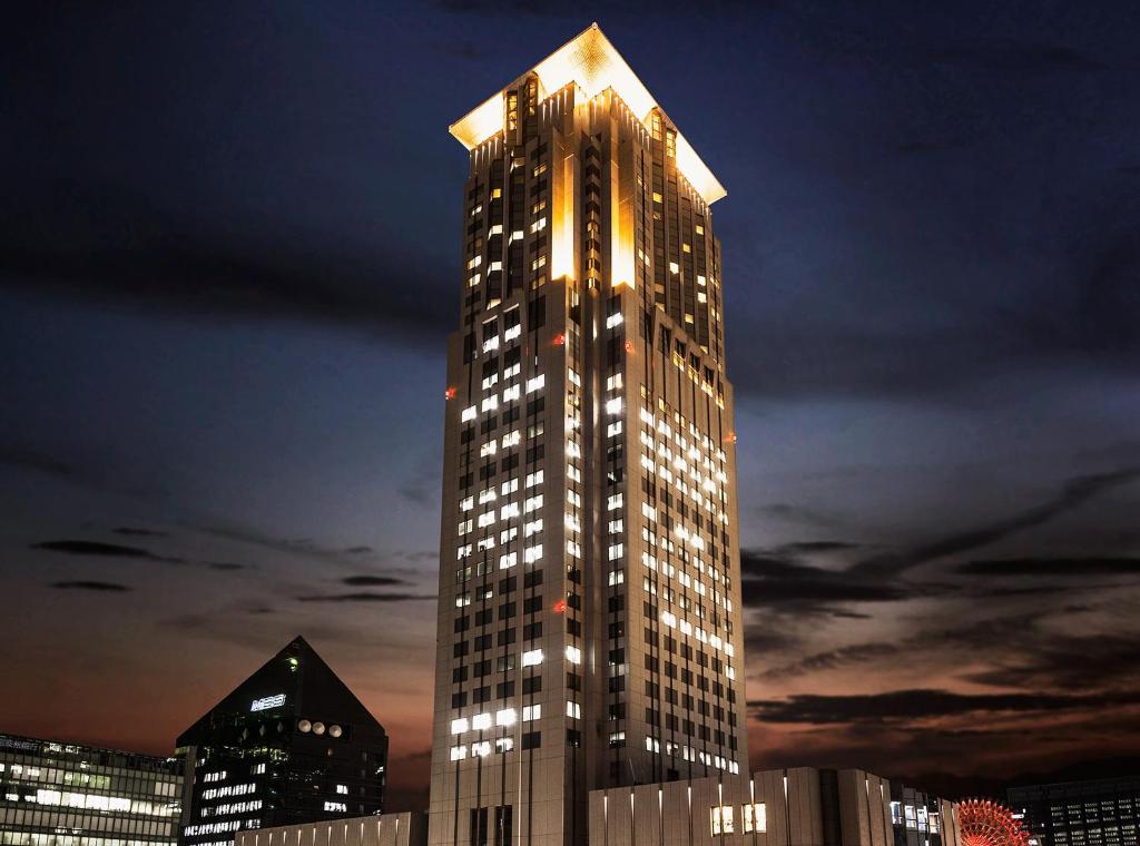 a tall building with lights on top of it at Hotel Hankyu International in Osaka