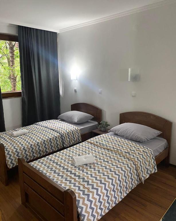two beds sitting in a room with a window at Hotel Lane in Kraljevo