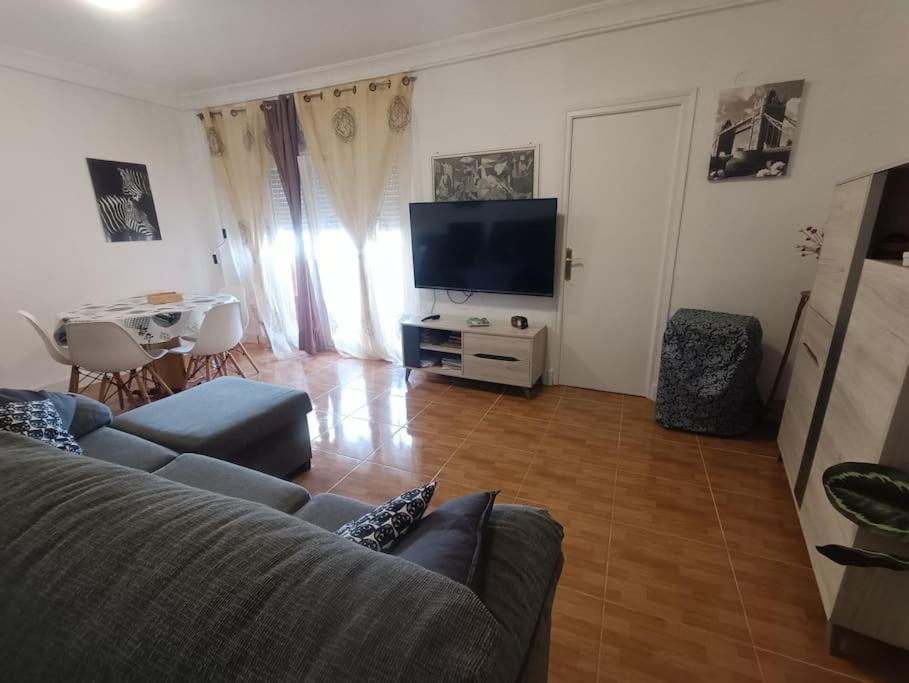 a living room with a couch and a flat screen tv at La casa de Emma in Piles