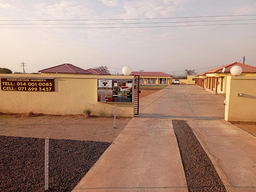 un edificio con un letrero al lado de una calle en Maboe Leisure Resort, en Rustenburg