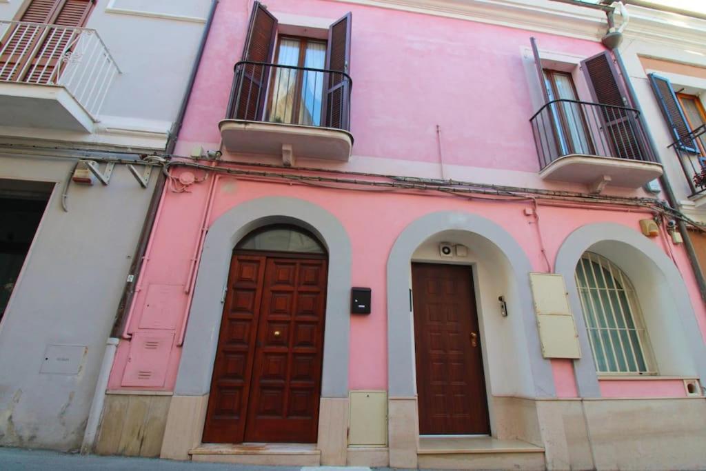 un edificio rosa con dos puertas en una calle en La Rustica mini apartment en Ortona