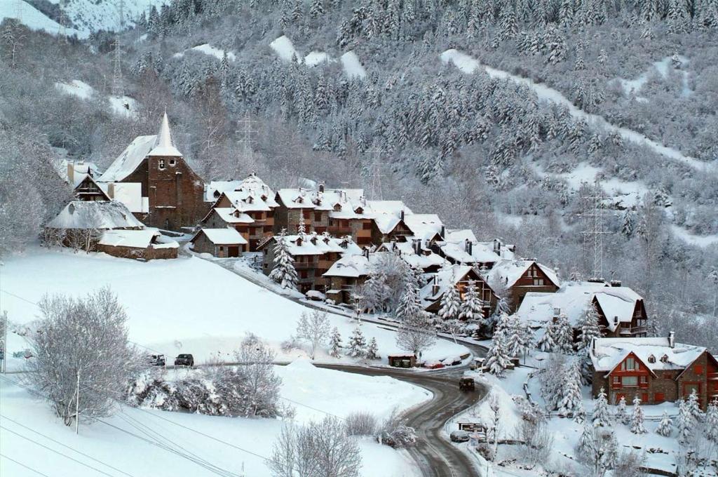 uma aldeia coberta de neve com uma montanha em ERA CASETA em Tredós
