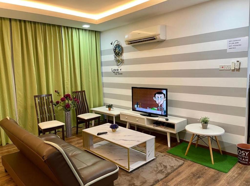 sala de estar con sofá y TV en VIVACITY SUITES , 2-8PAx 2CARD LEVEL 12, en Kuching