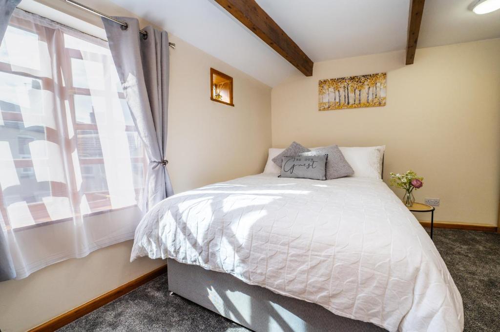 a bedroom with a large bed and a window at Cosy Cottage in Historic Lincoln in Lincolnshire
