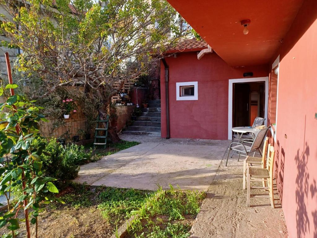 une maison rouge avec une table et des chaises à l'extérieur dans l'établissement Άνετη κατοικία με κήπο, à Kastoria