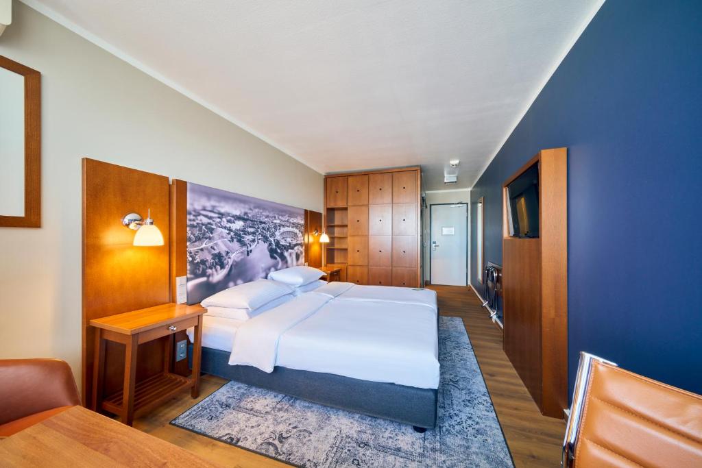 a bedroom with a large white bed and a couch at Arthotel Ana im Olympiapark in Munich