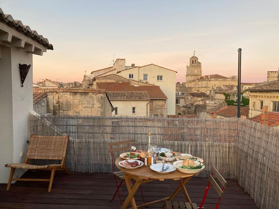 a table with plates of food on a balcony at Appartement lumineux, terrasse, centre historique in Arles