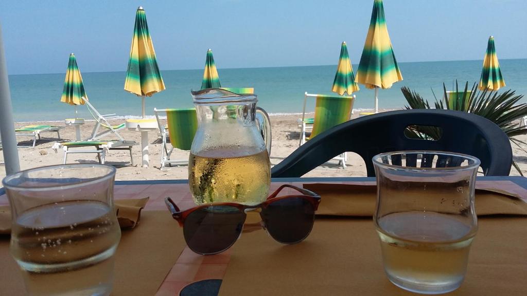 ロゼート・デッリ・アブルッツィにあるDonizetti Apartment 6のビーチとビールのボトル1本とグラス付きテーブル