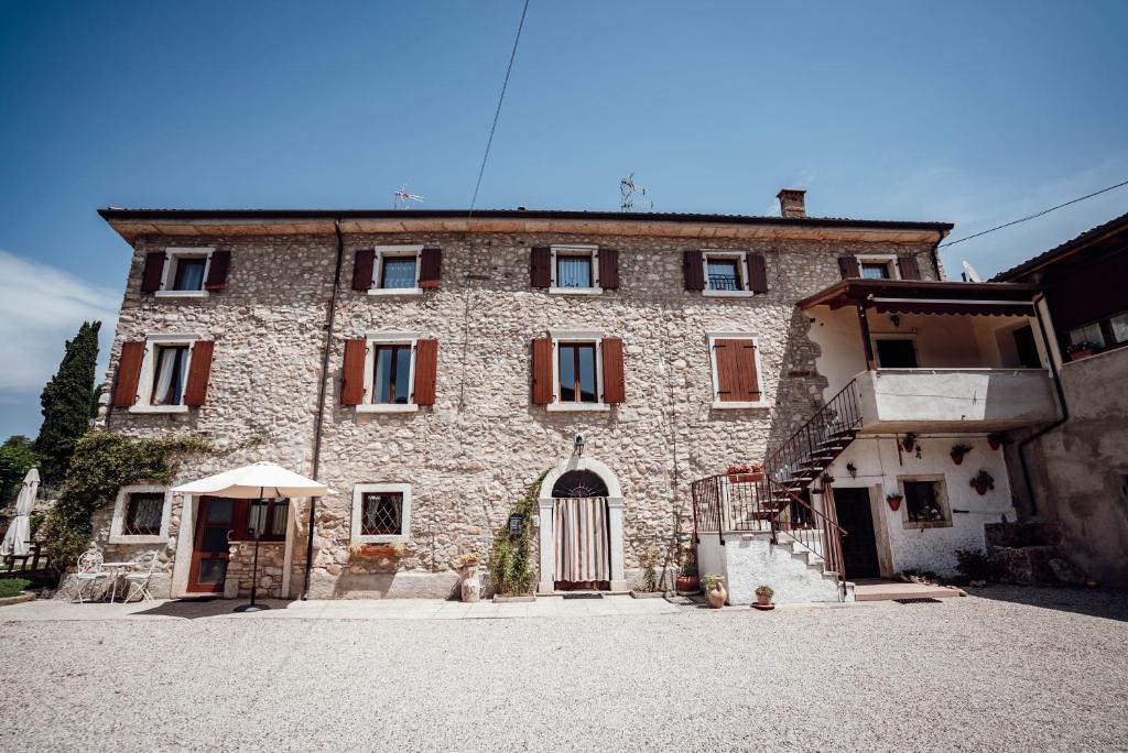 un grande edificio in pietra con una porta aperta su una strada di Corte Isabel a Costermano