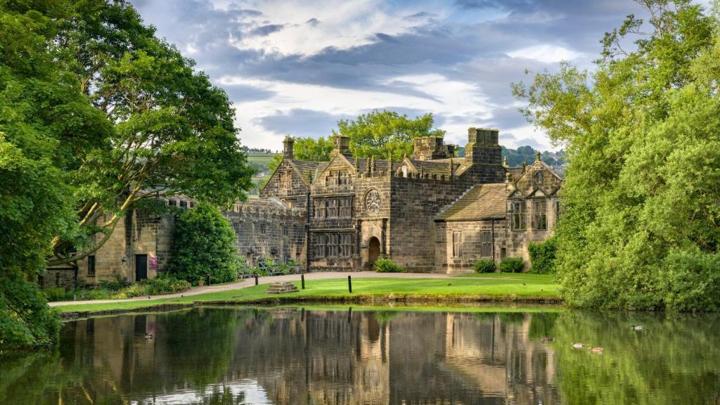 an old castle with a lake in front of it at Contemporary apartment Great Location with private carpark in Keighley