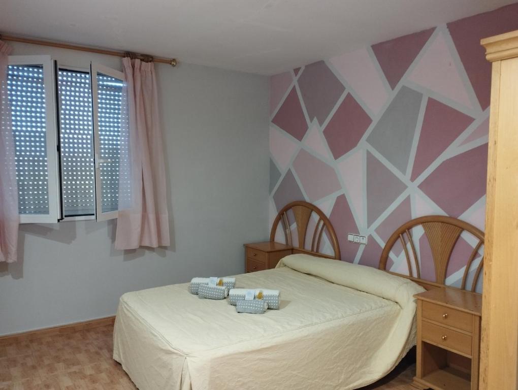 1 dormitorio con cama y pared geométrica en Hostal Restaurante LA CEPA, en Cenicero