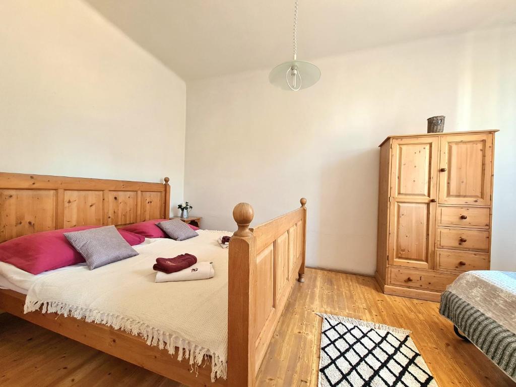 - une chambre avec un lit en bois et une commode dans l'établissement Úzkokolejky - apartmány Nová Bystřice, à Nová Bystřice