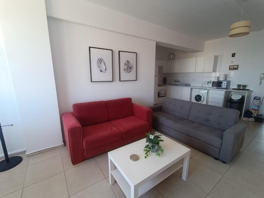 a living room with a red couch and a coffee table at Heart of the City in Limassol