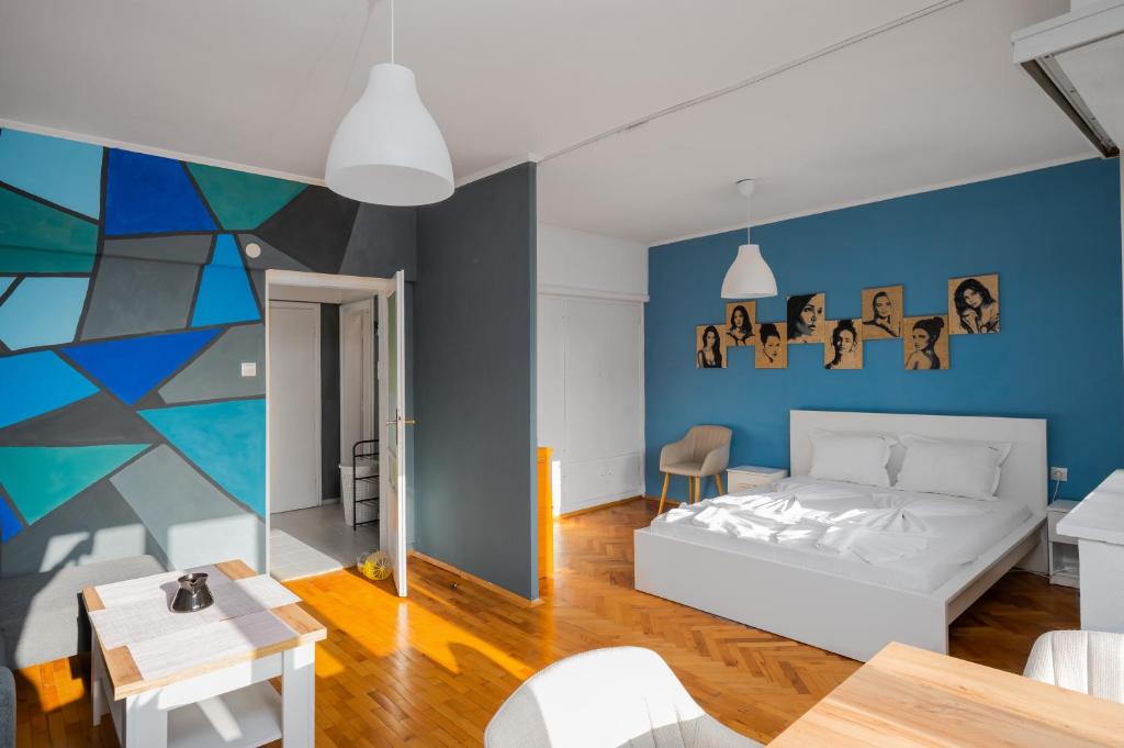 sala de estar con cama blanca y pared azul en Prime Location in City Center I The Blue Art Spot, en Sofía