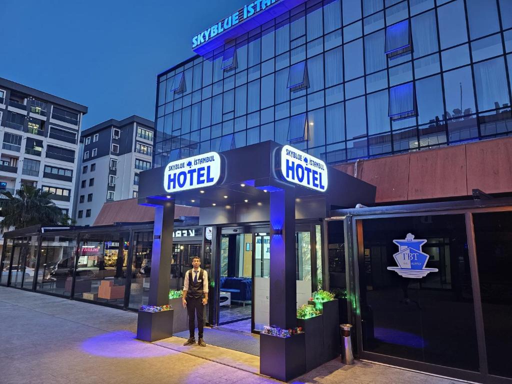 Um homem está em frente a um hotel. em SKYBLUE İSTANBUL HOTEL em Istambul