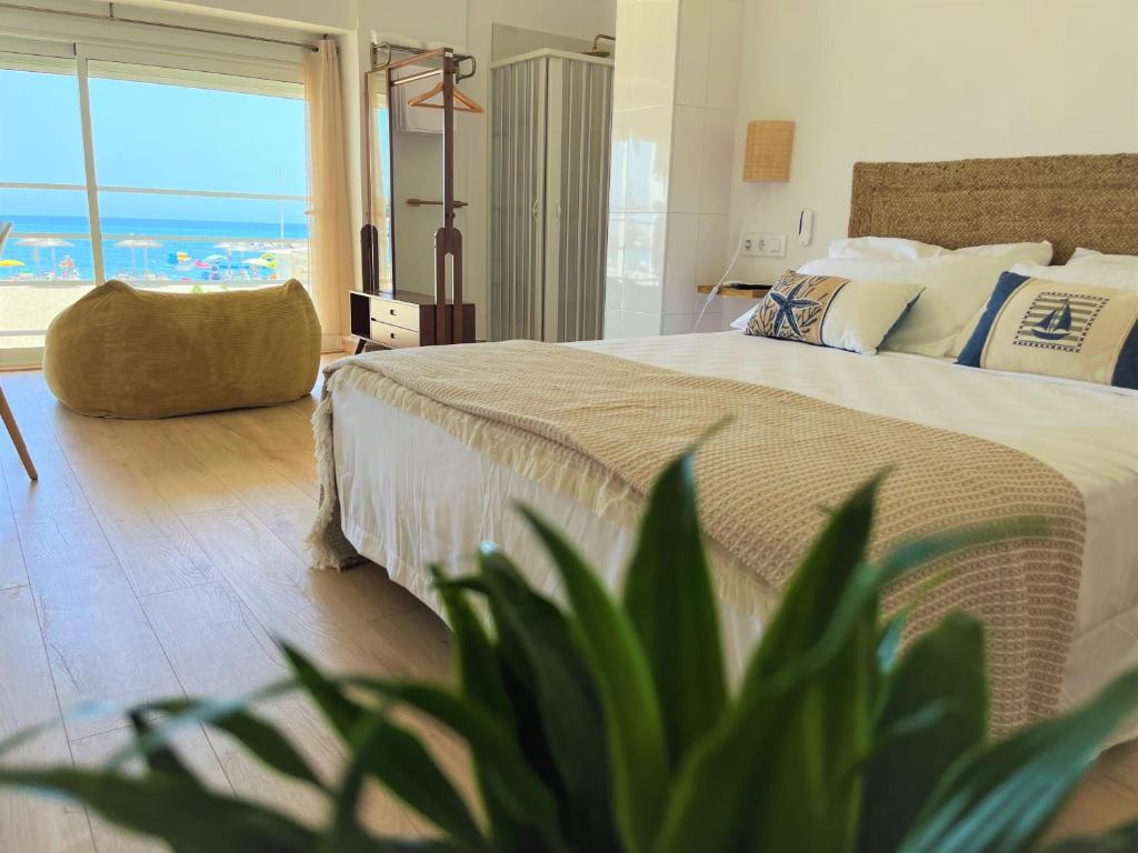 a bedroom with a large bed with a view of the ocean at Hostal playa Dreams náutico in Garrucha