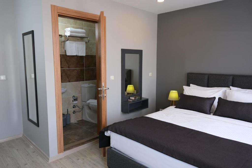 イスタンブールにあるOre Pera Suitesのベッドルーム(大型ベッド1台付)、バスルームが備わります。