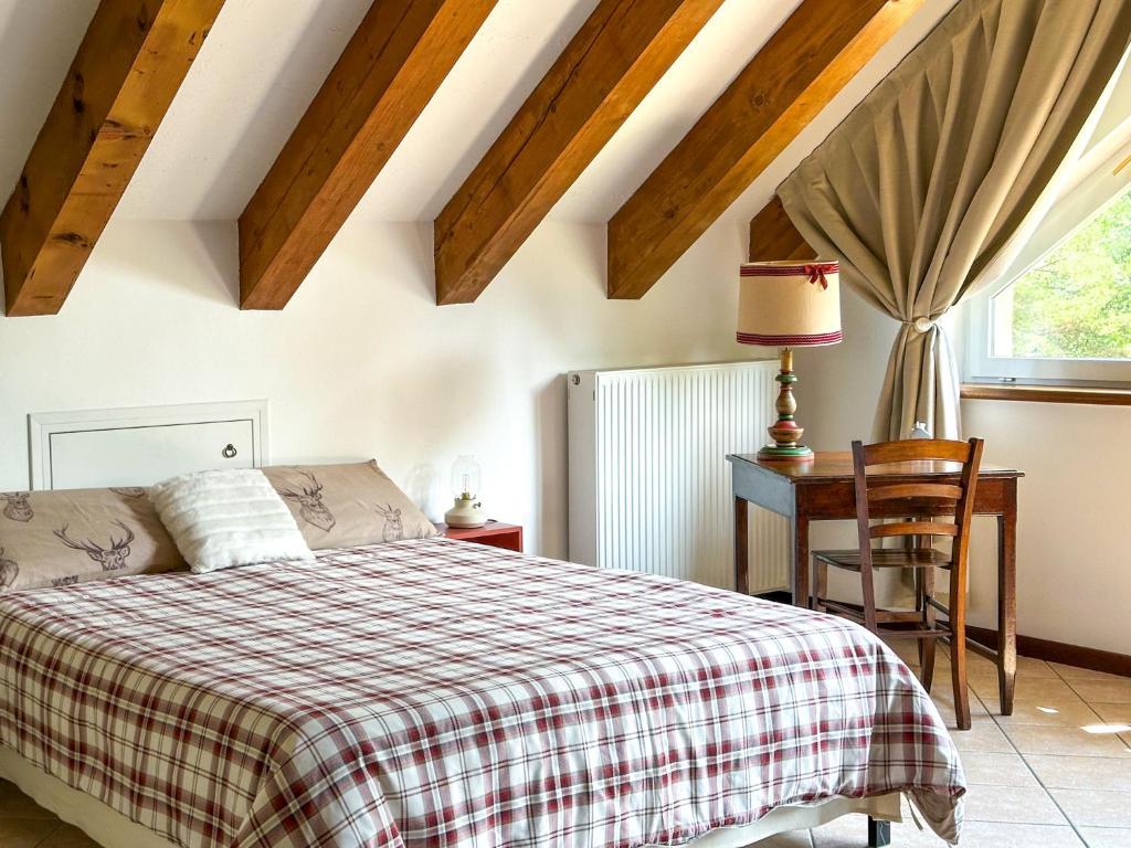 Craveggia的住宿－Le Mansarde di Siberia，一间卧室配有一张床、一张书桌和一个窗户。
