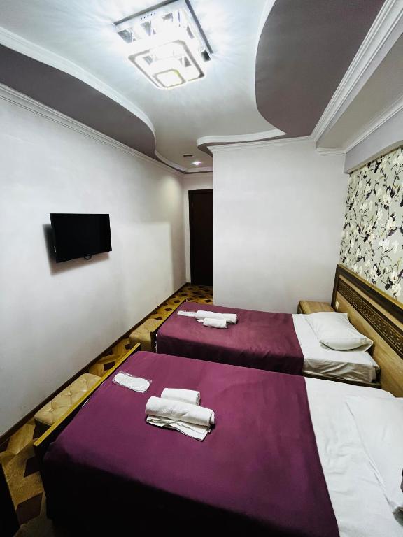 a hotel room with two beds and a flat screen tv at Georgian Palace Hotel in Kutaisi