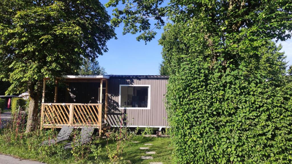 Une pièce d'une petite maison derrière une haie dans l'établissement Glamping Wallersee - Unter dem Kastanienbaum, à Helming