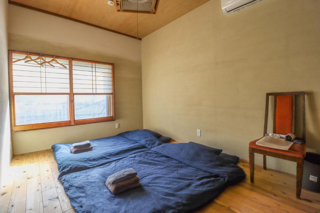 a bedroom with a bed with blue sheets and a mirror at 旧邸稽古場 in Tokyo