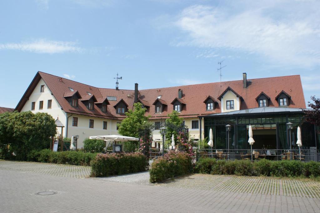 a large house with a building with a roof at Hotel Landgasthof Hofmeier in Hetzenhausen