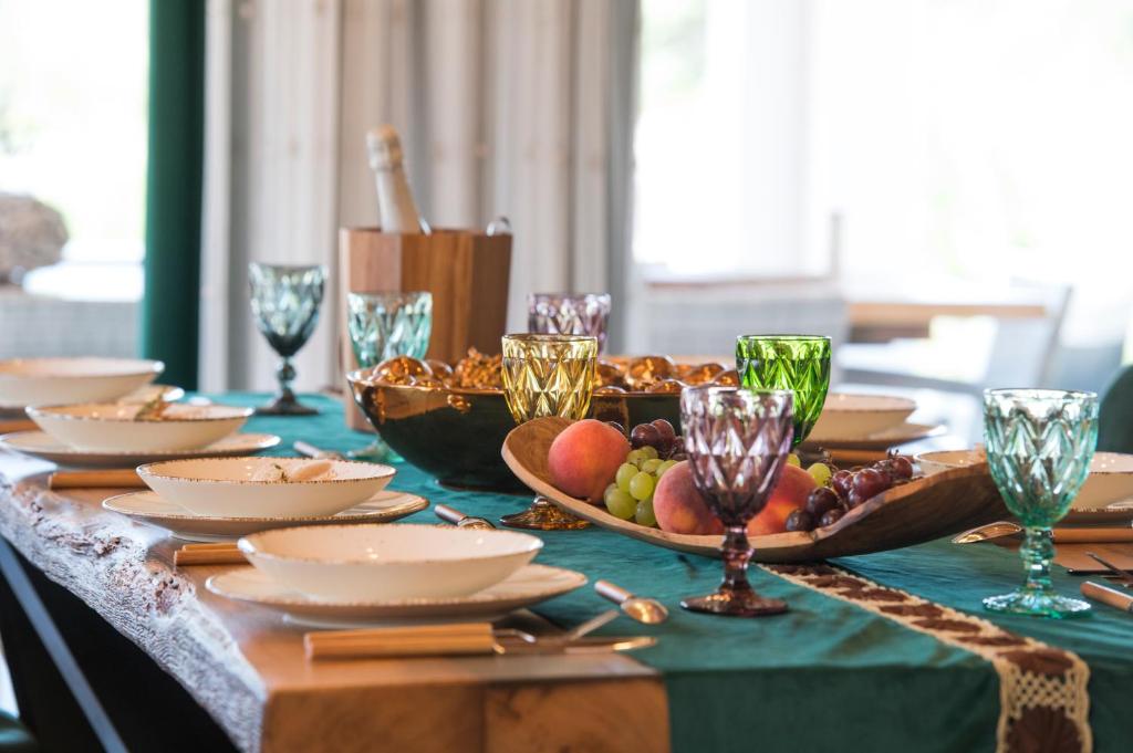 a table with a plate of fruit and wine glasses at Luxury Villa Nature with heated private pool, sauna & fire pit, a short walk to the beach in Milna