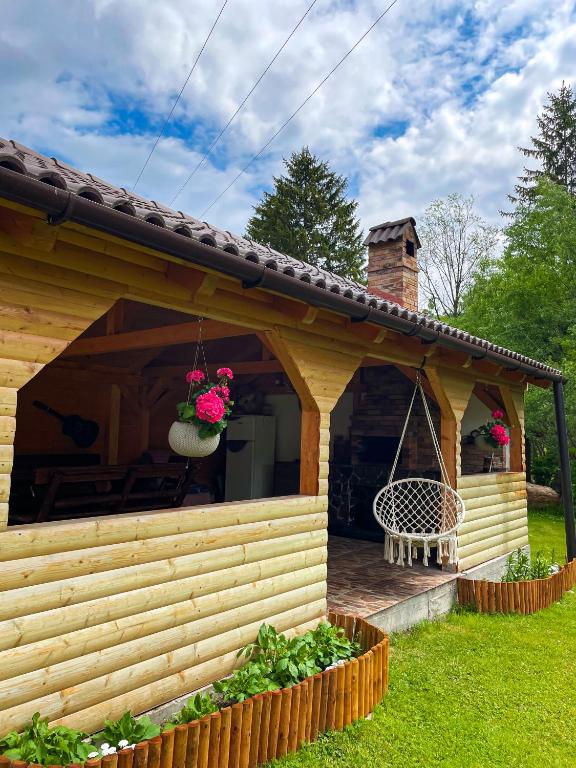 a wooden cabin with a porch with a swing at Vila Lilica in Bran