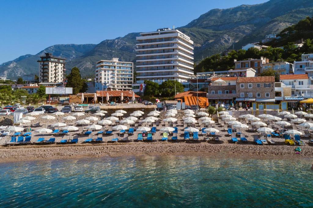 a group of umbrellas and chairs on a beach at Hotel Sato in Sutomore