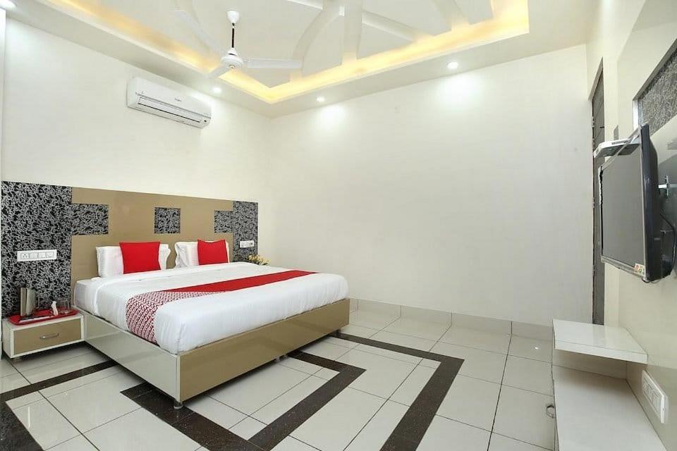 a bedroom with a bed and a flat screen tv at LUCKY HOTEL AND RESTAURANT in Kurukshetra
