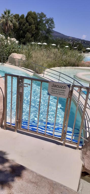 a sign on a railing next to a swimming pool at les Restanques Du Golf de Saint Tropez, 83310 Grimaud, France Appartement in Grimaud