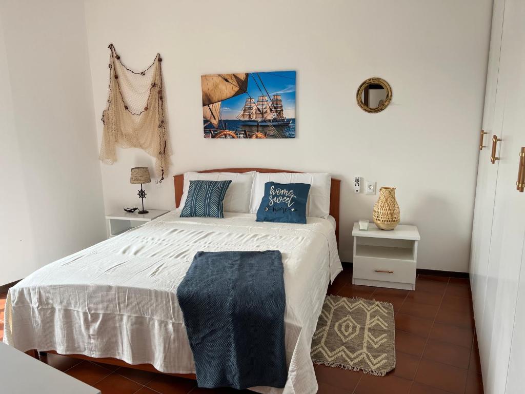 a bedroom with a large white bed with blue pillows at Beach apartments Spiaggia Nascosta in Silvi Marina