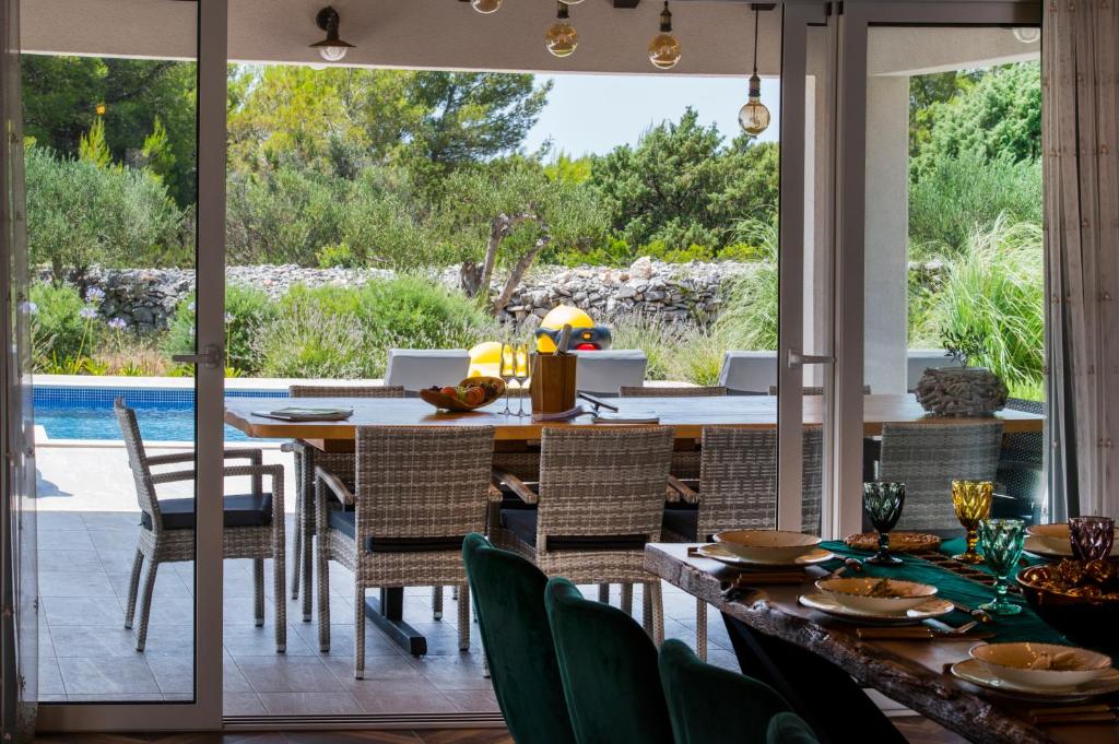 an open kitchen and dining room with a table and chairs at Luxury Villa Nature with heated private pool, sauna & fire pit, a short walk to the beach in Milna