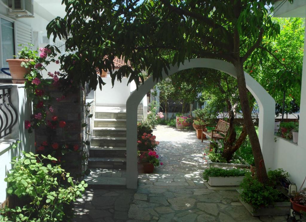 un jardín con un árbol y una pasarela de piedra en Loginos Studios, en Kallithea Halkidikis